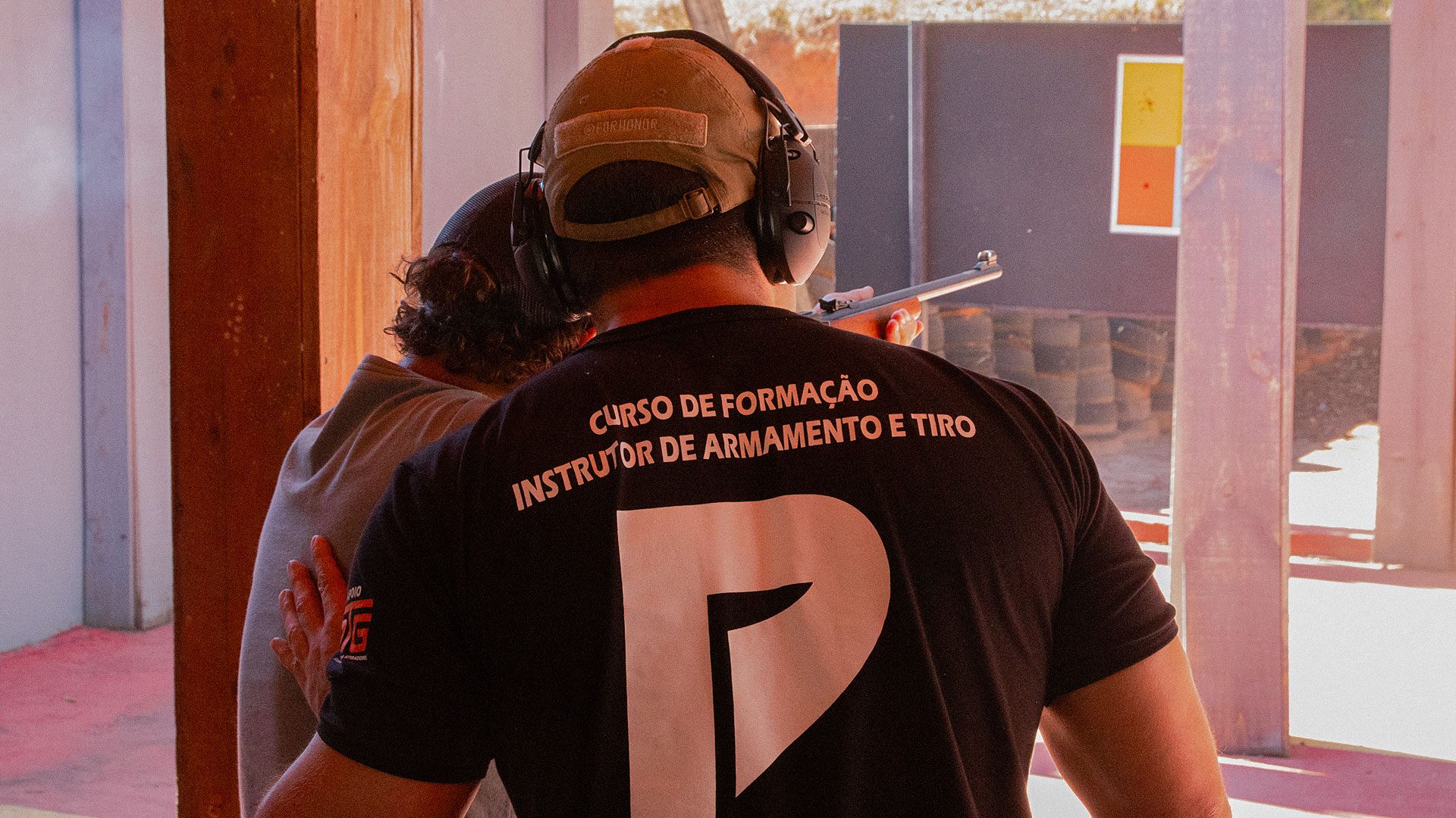 Aluno do curso IAT instruindo um colega na linha de tiro, na dinâmica de comando de linha