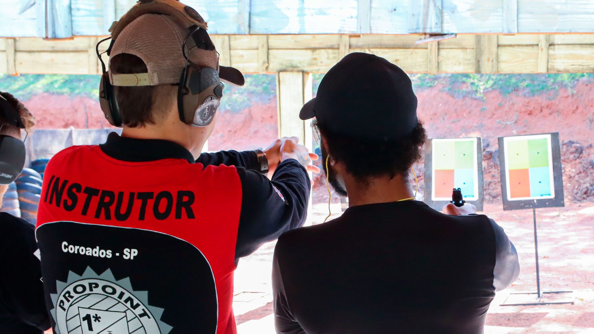 Instrutor da ProPoint corrigindo um aluno na linha de tiro durante o curso IAT